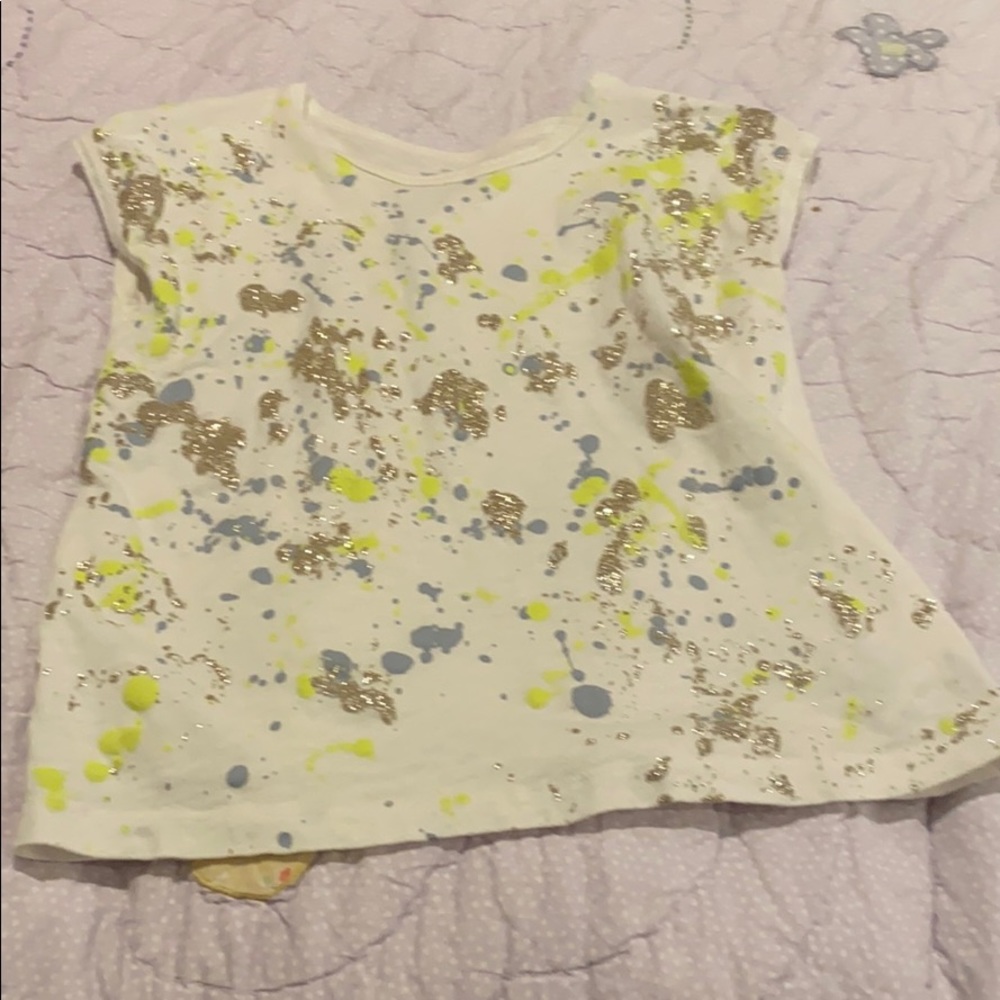 White shirt with blue, yellow, and gold paint.